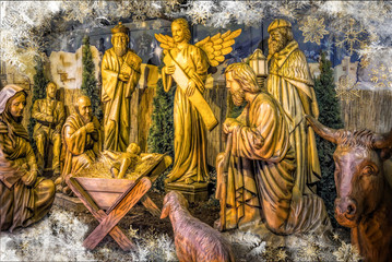 Wooden christmas figures in a nativity manger scene outdoors