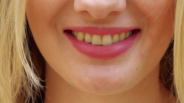 Smiling female mouth with natural color of teeth. Close up of smiling woman face with perfect smile.