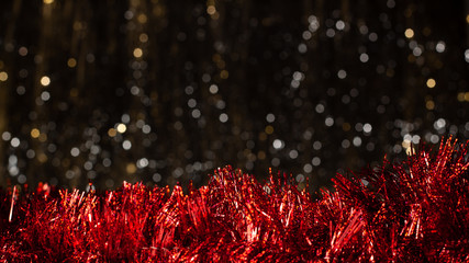 Christmas dark background with silver and gold colors bokeh and red decoration at the battom. Holiday concept with copy space