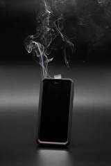 smoke coming from a smartphone with tape covering the phones camera