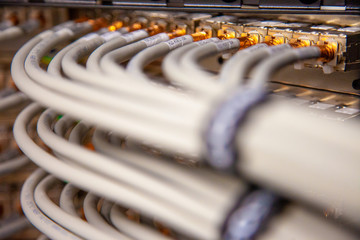 Sequence of white gold-tipped cables connected to a supercomputer.