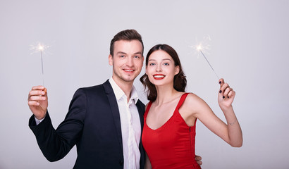 Portrait of lovers at a New Year's party with sparklers.