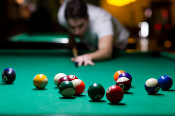 Young man playing pool in pub