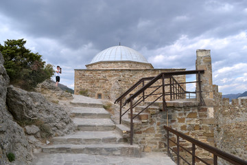 An ancient building on the territory of the Genoese fortress in Sudak against a background of thunderclouds. Crimea.
