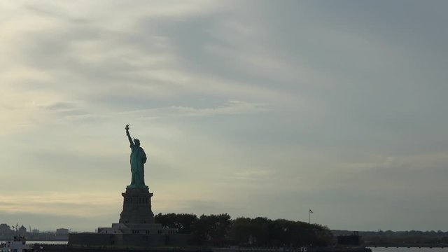 4K. Ultra HD. Zoom shot of the Statue of Liberty filmed at sunset from the East River, New York, United States of America. Statue of Liberty is one of the most famous monuments in New York.