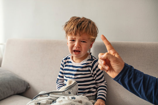 You Are Punished. Irritated Father Is Yelling At His Son. Strict Father Abuseshis Son. Dad Is Raising A Son. Little Boy Small Child Crying While Some Man Is Trying To Reach Him