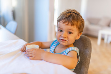 Eat healthy. Toddler having snack. Healthy nutrition. Drink milk. Child hold glass of milk. Kid...