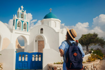 Santorini island traveler exploring greek church architecture in Akrotiri. Woman tourist walking during vacation