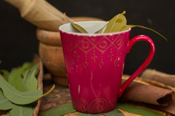 eucalyptus medicine tea over wood in dark background