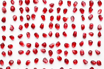 Ripe tasty pomegranate seeds on white background