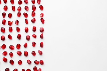 Ripe tasty pomegranate seeds on white background