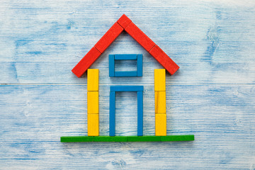 Flat lay house of building blocks on wood background