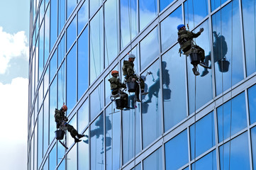 Industrial climbers wash windows of skyscraper