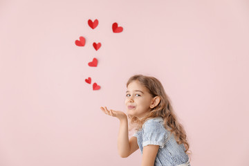 Obraz na płótnie Canvas Cute little girl sending romantic air kiss on color background. Valentines Day celebration