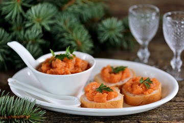 Canapes with caviar on an old wooden background.