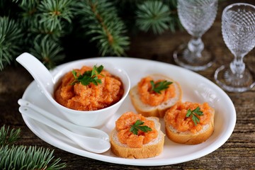 Canapes with caviar on an old wooden background.