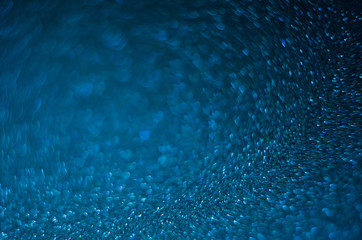 Abstract New Year blue bokeh background with shining defocus sparkles. Blurred glitters shimmering dust macro close up, copy space for text logo
