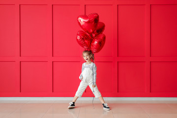 Cute little girl with air balloons on color background. Valentines Day celebration