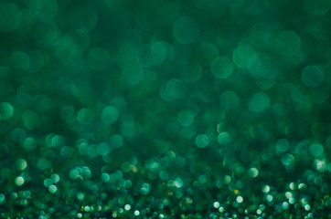 Abstract New Year emerald bokeh background with shining defocus sparkles. Blurred glitters shimmering dust macro close up, copy space for text logo - obrazy, fototapety, plakaty