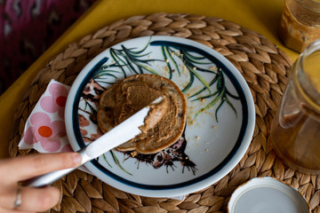 Spreading peanut butter to american pancake, delicious breakfast