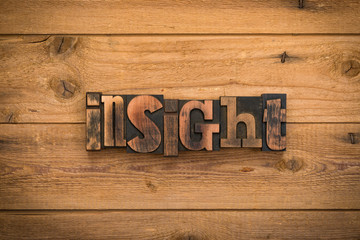 Insight, word written with vintage letterpress printing blocks on rustic wood background