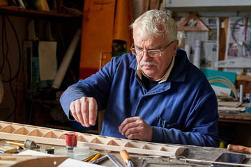 Senior man who makes the wing of a radio-controlled aircraft, the construction of the airplane.