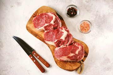 Fresh raw rib eye steak on a light background. Organic food. Top view.