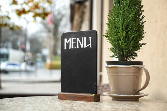 Empty menu board on table in outdoor cafe