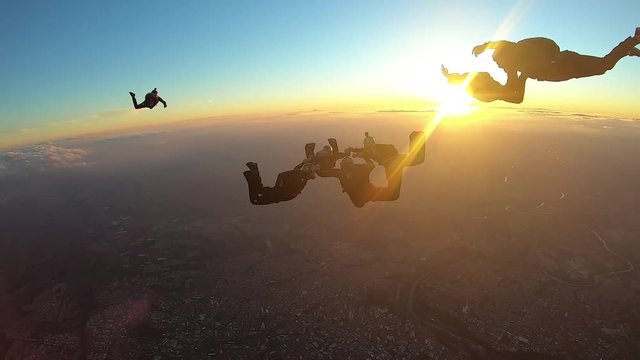 Skydivers make a formation skydive at the sunset slow motion
