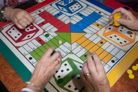 Women playing parcheesi board game