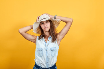 Obraz na płótnie Canvas Attractive young woman in blue denim shirt holding hands over head, looking funny isolated on orange background in studio. People sincere emotions, lifestyle concept.