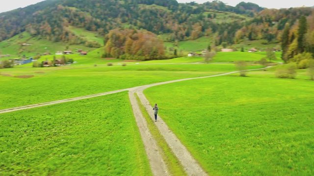 Woman runs at the crossroads.  Drone tracking focus. Aerial shot from the coptere.4K