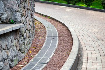 grille of the drainage system on the curve pedestrian sidewalk of turn on the side of the sidewalk...