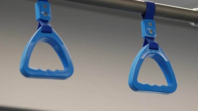 Plastic blue handle grip hang on nylon belts in the cars of the Moscow Central Ring. Handles hang out in time with the subway train. Public transport. MCC railway in the city