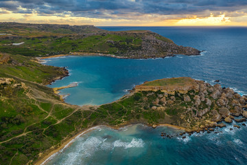 Fototapeta premium Aerial view of Ghajn Tuffieha Bay. Sunset sky, clouds, sea, winter. Malta island