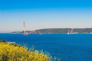Fototapeta na wymiar Istanbul, Turkey, 9 May 2015: Yavuz Sultan Selim Bridge, Rumeli Kavagi, Ship at Bosphorus.