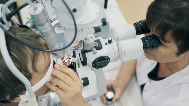 Female doctor checking patient's eyes at a clinic.