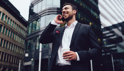Happy man in formal wear calling to friend for communicate during business work break in financial district using 4g roaming international connection from operator system, concept of service talking