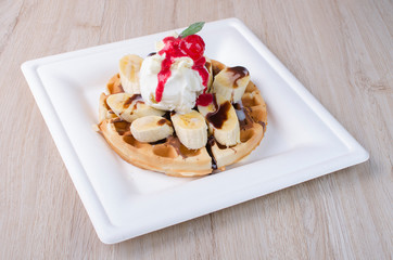 waffles with ice cream, chopped fruit and sauces