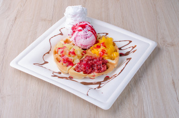 waffles with ice cream, chopped fruit and sauces