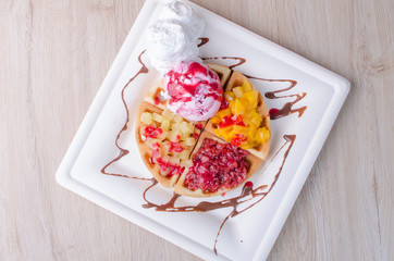 waffles with ice cream, chopped fruit and sauces