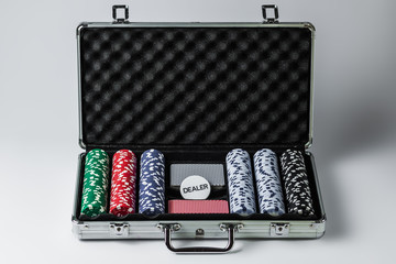 Suitcase with poker set on a light background