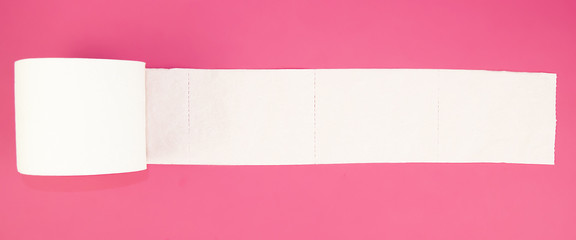 white toilet paper roll on pink background