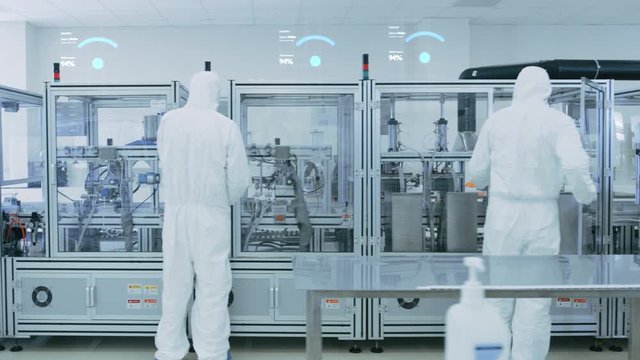 Manufacturing Facility Workers Assembling Products Using Industrial High Precision Machinery. Special Effects Animation: Wi-Fi Connected Icons with Completion Progress