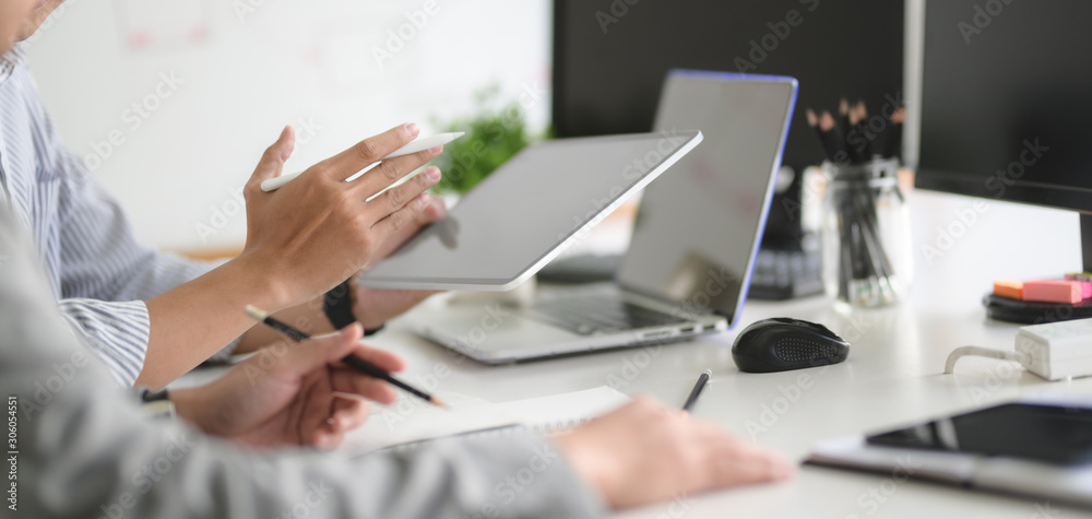Sticker cropped shot of ux web developer team working on his project together with tablet and laptop