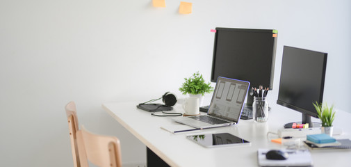 Cropped shot of modern UX web developer team workplace desktop computer and laptop computer