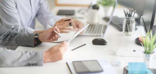 Cropped shot of UX web developer team working on his project together with tablet and laptop