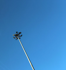 The stadium lights in front of the blue sky