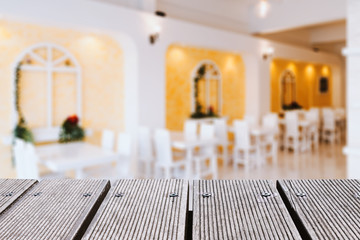 Empty wood table top and blurred bokeh cafe and restaurent background.