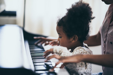 Mother is teaching piano tricks, African people © chokniti